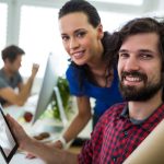 Male and female graphic designers using digital tablet in office
